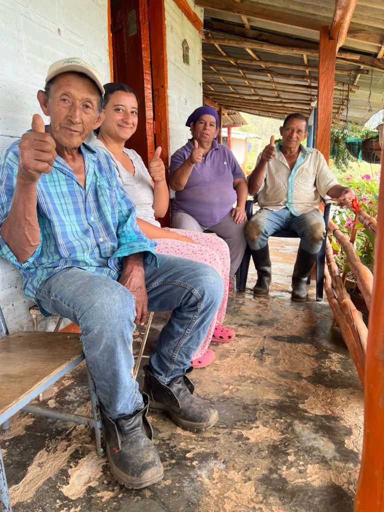 Familia sentada, sonriente y agradeciendo por la vivienda digna.